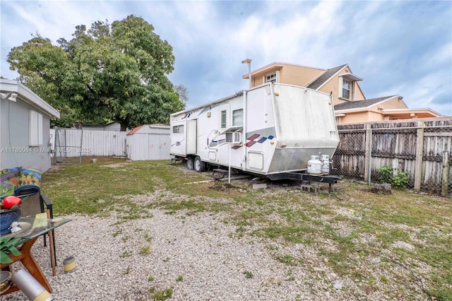 view of yard with an outbuilding, a storage unit, and a fenced backyard