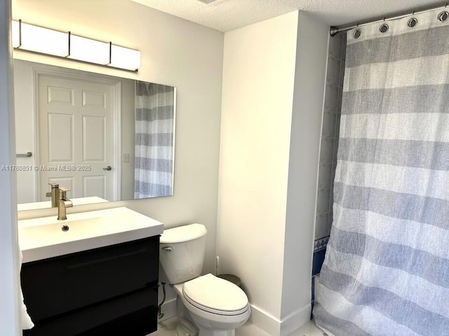 bathroom with toilet, vanity, a shower with curtain, baseboards, and a textured ceiling