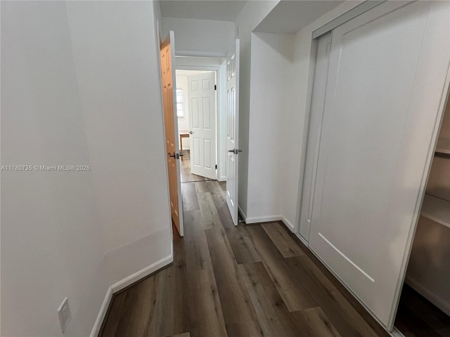 corridor with baseboards and dark wood finished floors