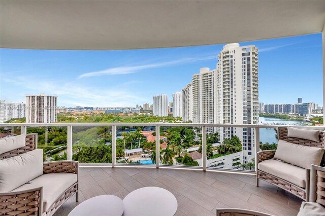 balcony featuring a water view and a city view