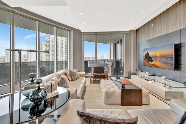 living area with recessed lighting, a city view, and a wall of windows