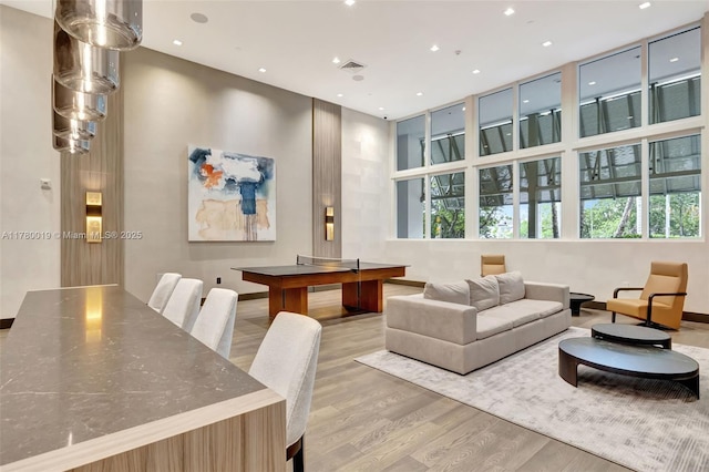living area with visible vents, recessed lighting, and wood finished floors