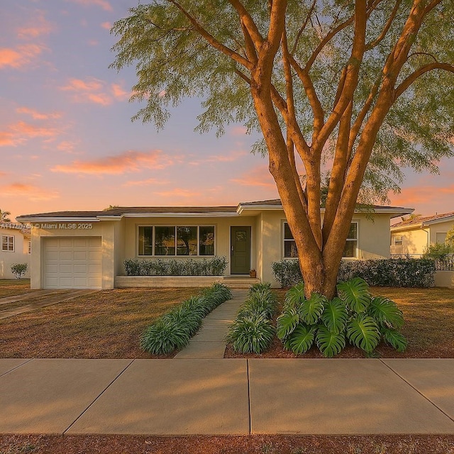 view of front of house featuring a garage, stucco siding, and concrete driveway