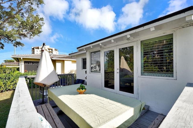 wooden deck with outdoor dining area and french doors