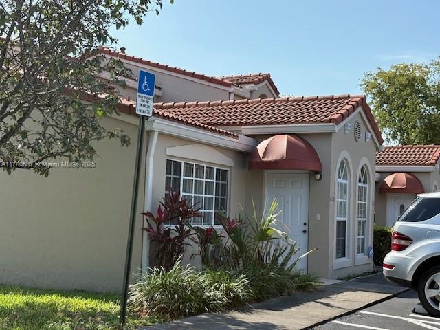 6720 NW 166th Ter Unit 401, Miami Lakes, FL 33014 - view of home's exterior with stucco siding and a tiled roof