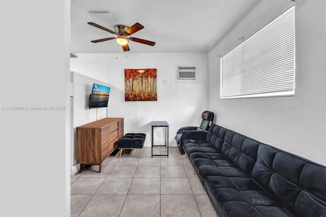 living area with a ceiling fan, light tile patterned floors, and an AC wall unit