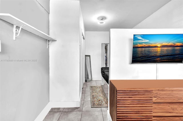 hall featuring tile patterned flooring and baseboards