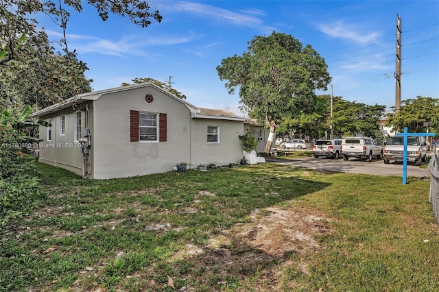 view of home's exterior featuring stucco siding and a yard
