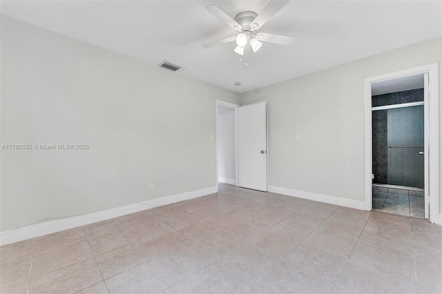unfurnished bedroom featuring visible vents, baseboards, ensuite bathroom, a ceiling fan, and light tile patterned flooring