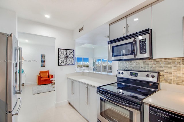 1500 Bay Rd Unit 1540S, Miami Beach, FL 33139 - kitchen with decorative backsplash, light countertops, visible vents, and appliances with stainless steel finishes