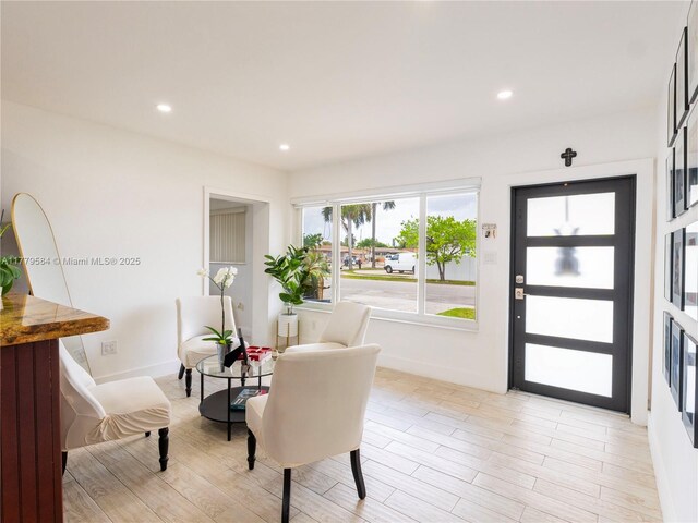 foyer featuring baseboards, light wood finished floors, and recessed lighting