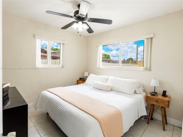 bedroom featuring ceiling fan, baseboards, and light tile patterned floors