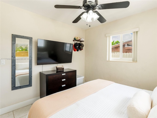 tiled bedroom with baseboards and a ceiling fan
