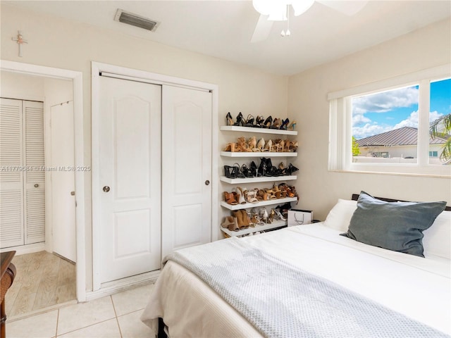 bedroom featuring visible vents, ceiling fan, a closet, and light tile patterned flooring