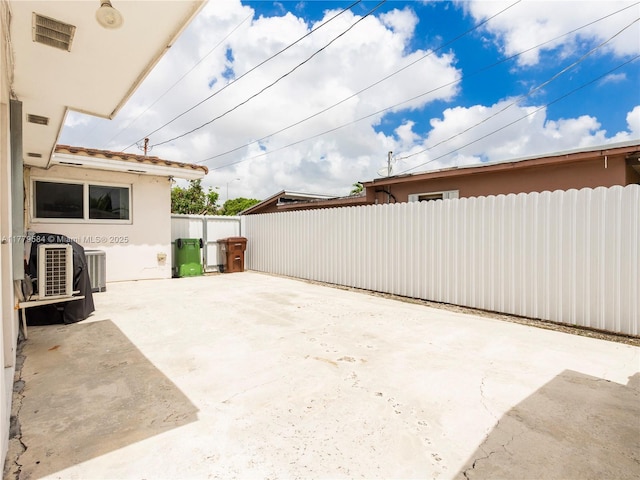 view of patio featuring visible vents, fence, and cooling unit