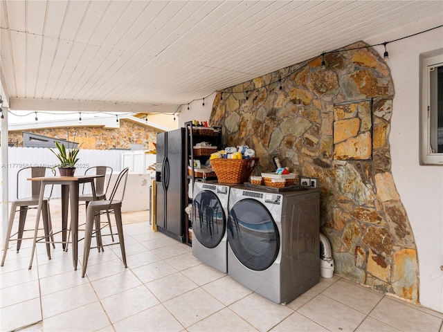 washroom featuring laundry area, wooden ceiling, light tile patterned floors, and washer and clothes dryer