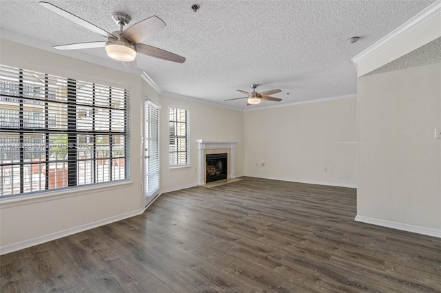 unfurnished living room featuring ornamental molding, a fireplace with flush hearth, dark wood-style flooring, and a ceiling fan