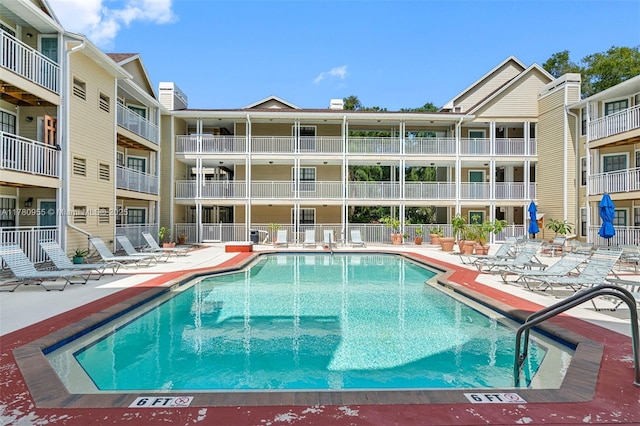 community pool with a patio and fence