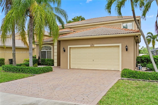 4475 Banyan Trails Dr, Coconut Creek, FL 33073 - mediterranean / spanish house featuring a tiled roof, a garage, stucco siding, and decorative driveway