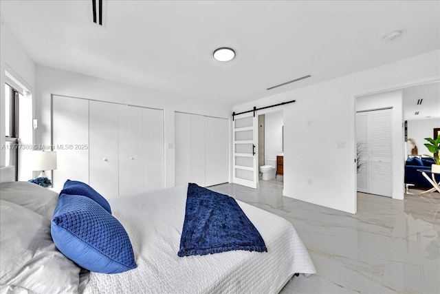 2021 SW 23rd St, Miami, FL 33145 - bedroom featuring marble tiled flooring, multiple closets, a barn door, and ensuite bathroom