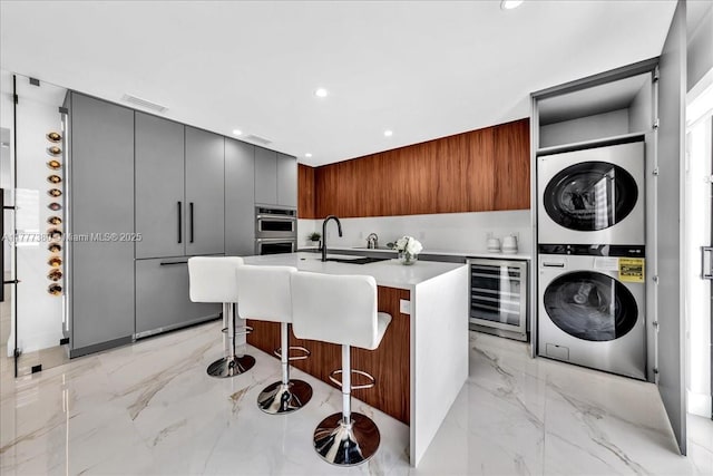 2021 SW 23rd St, Miami, FL 33145 - laundry room with stacked washing machine and dryer, beverage cooler, light marble finish floors, and recessed lighting