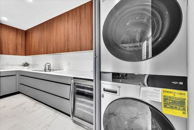 2021 SW 23rd St, Miami, FL 33145 - washroom with stacked washing machine and dryer, light marble finish floors, beverage cooler, and recessed lighting