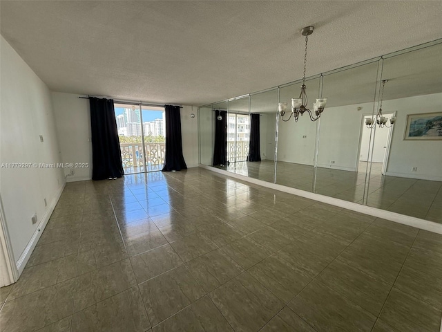 1825 S Ocean Dr Unit 503, Hallandale Beach, FL 33009 - unfurnished room featuring expansive windows, a chandelier, a textured ceiling, and dark tile patterned flooring