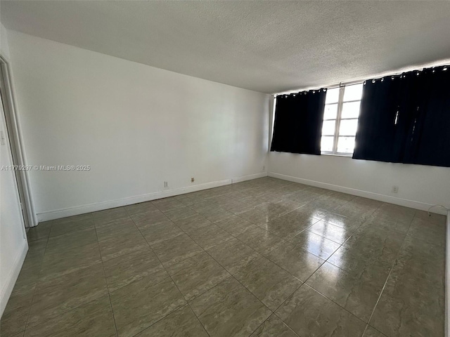 1825 S Ocean Dr Unit 503, Hallandale Beach, FL 33009 - spare room with a textured ceiling and dark tile patterned flooring