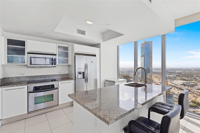 kitchen featuring visible vents, appliances with stainless steel finishes, a sink, and light tile patterned floors