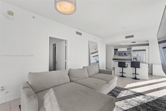 living room featuring visible vents and light tile patterned floors