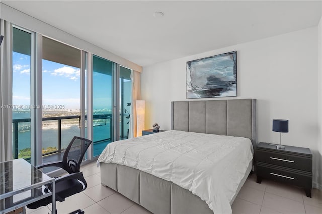 bedroom with floor to ceiling windows, a water view, access to exterior, and light tile patterned floors