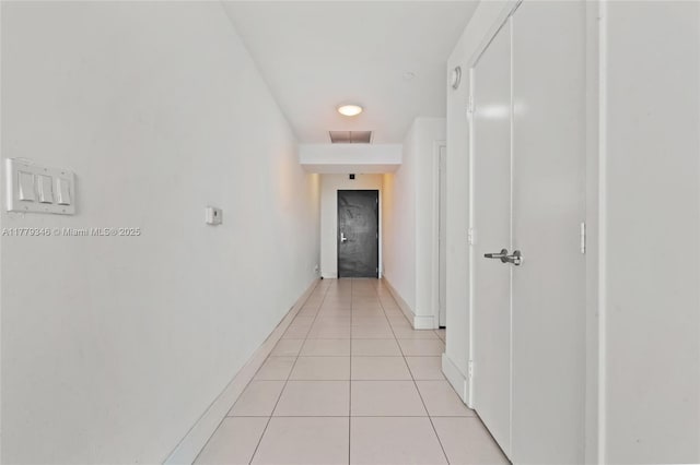 hall with baseboards, light tile patterned flooring, and visible vents