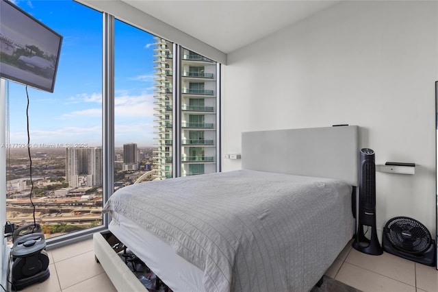 bedroom with a view of city, tile patterned floors, and floor to ceiling windows