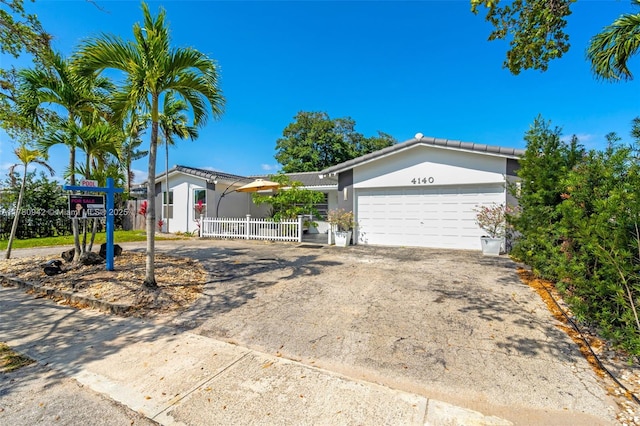 4140 N 36th Ave, Hollywood, FL 33021 - view of front of house with driveway, stucco siding, fence, and an attached garage