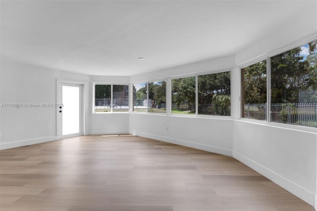 1301 NE 191st St Unit F117, Miami, FL 33179 - unfurnished sunroom featuring wood finished floors and baseboards