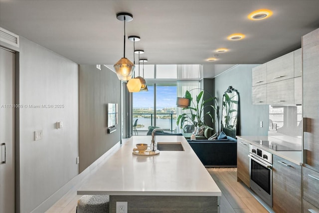 kitchen featuring modern cabinets, a sink, black electric stovetop, a water view, and oven