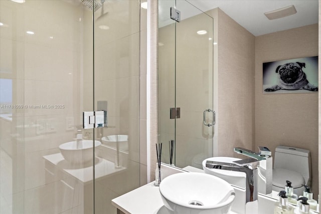 bathroom with vanity, a stall shower, and toilet