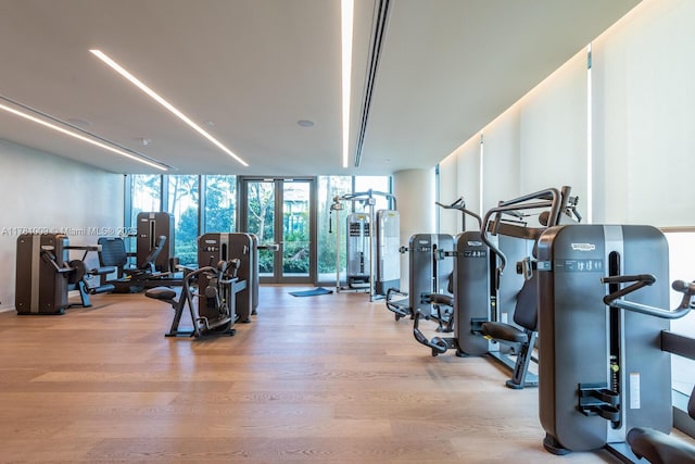 exercise room featuring expansive windows and wood finished floors