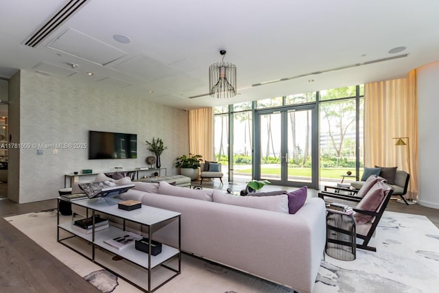 living room with wallpapered walls, a wall of windows, and wood finished floors