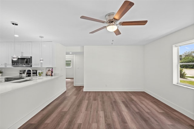 kitchen featuring white cabinetry, light countertops, a ceiling fan, appliances with stainless steel finishes, and a sink
