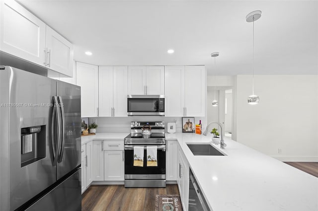 kitchen featuring stainless steel appliances, dark wood-style flooring, light countertops, and a sink