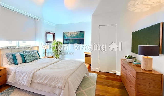 bedroom featuring wood finished floors and baseboards