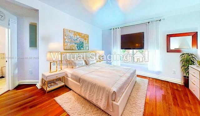 bedroom with baseboards and wood finished floors