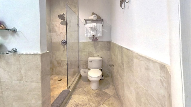 full bath with tile walls, toilet, walk in shower, and wainscoting