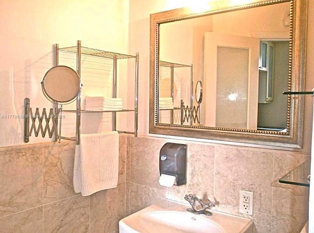 bathroom with tile walls and a sink