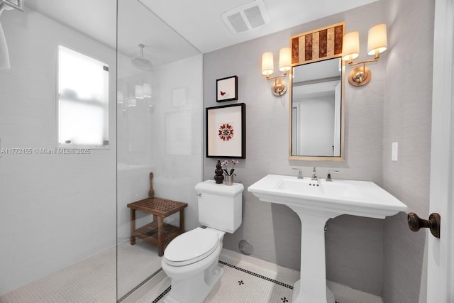 bathroom with tile patterned floors, visible vents, toilet, a sink, and walk in shower