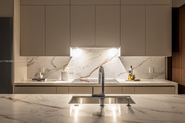 kitchen featuring a sink, decorative backsplash, modern cabinets, and light stone counters