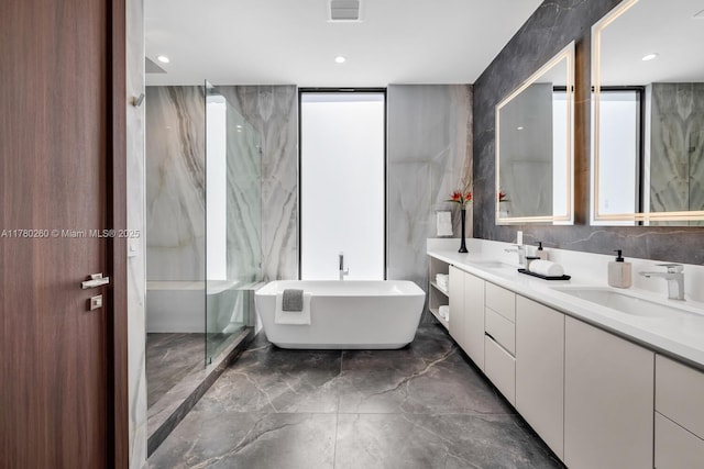 full bath with a sink, a freestanding bath, visible vents, and marble finish floor