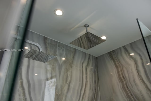 interior details featuring a marble finish shower