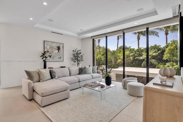 living room featuring recessed lighting and a raised ceiling